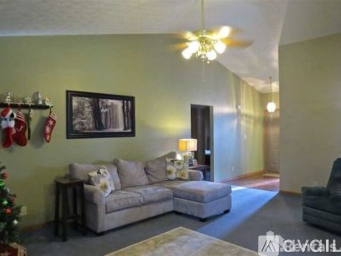 A living room with a Christmas tree and a picture on the wall.