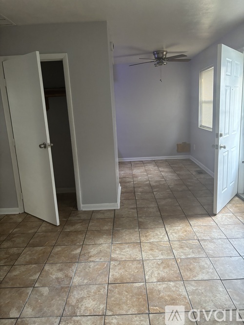 A room with a ceiling fan and tile flooring.