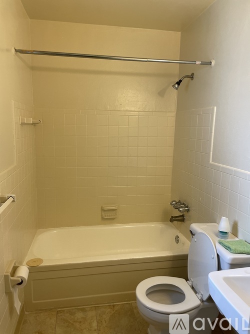 A white bathroom with a toilet, sink, and bathtub.