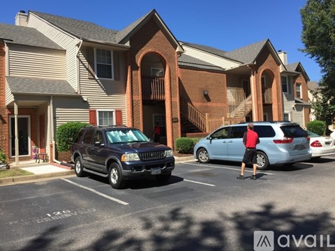 A black SUV is parked in a parking lot in front of a brick building.