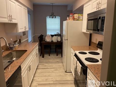 A kitchen with white cabinets and a granite countertop.