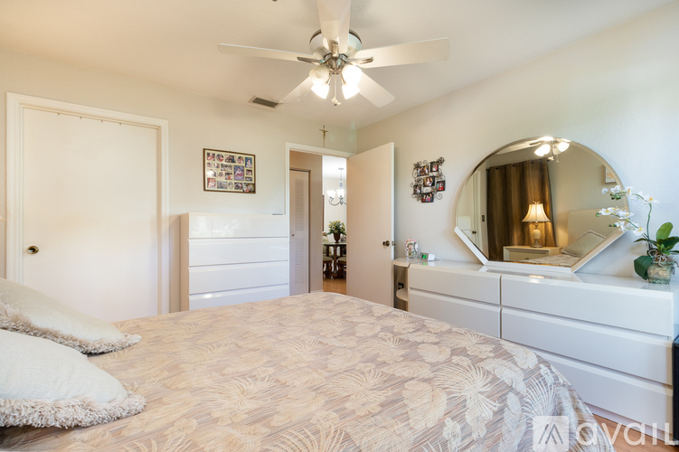A bedroom with a large bed and a mirror on the wall.