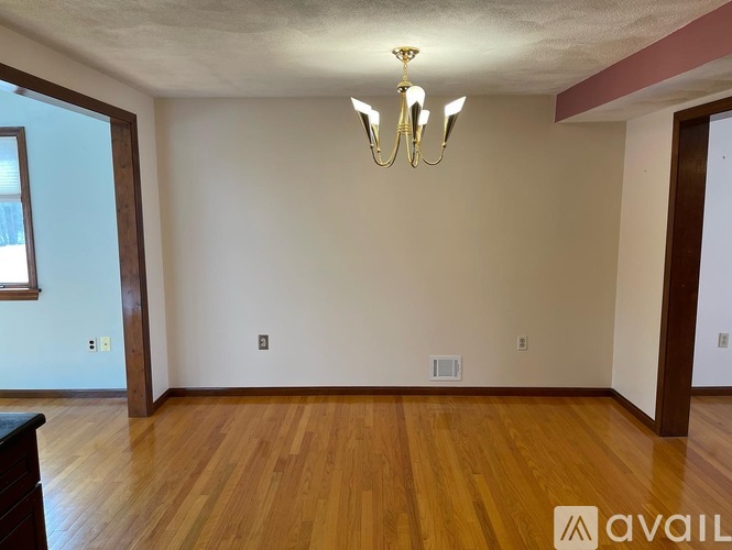 A room with wooden floors and a chandelier.