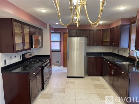 A kitchen with a refrigerator, stove, and cabinets.