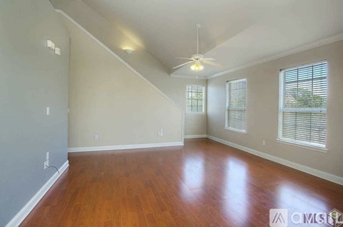 A room with wooden floors and a ceiling fan.
