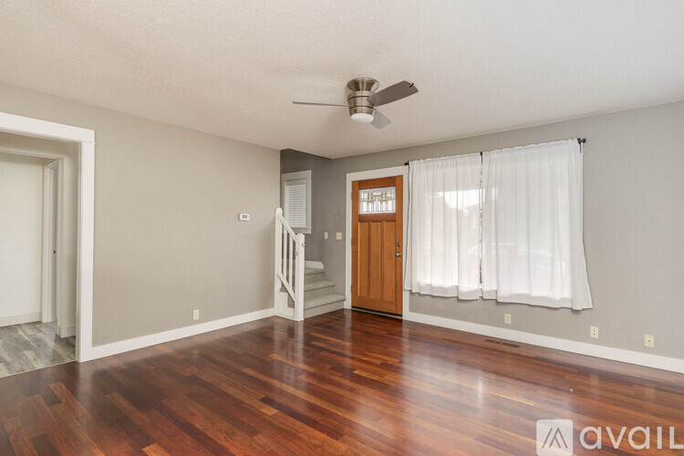 A room with wooden floors and a ceiling fan.