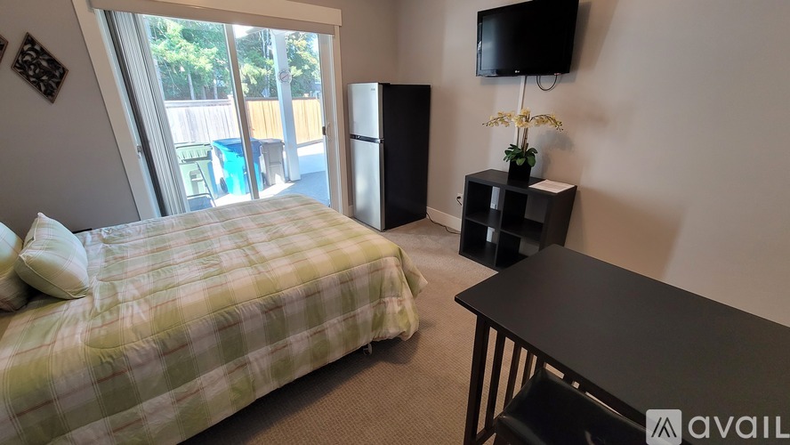 A bedroom with a bed, a table, and a television.