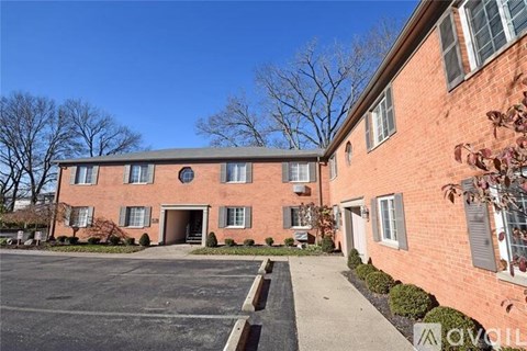 A red brick building with a parking lot in front.