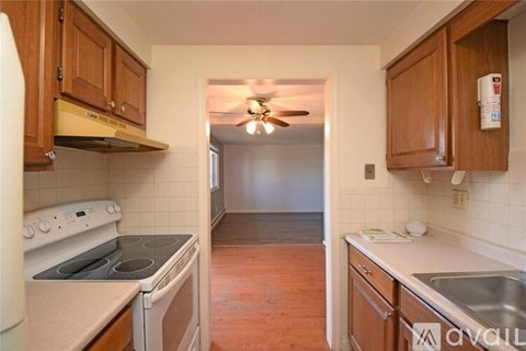 A kitchen with wooden cabinets and a stove top oven.