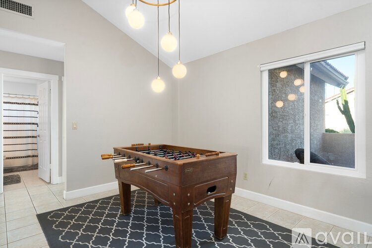 A room with a pool table and a window.
