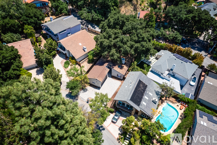 A bird's eye view of a residential area with houses and a swimming pool.