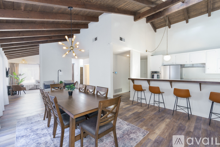 A modern dining room with wooden furniture and a bar area.