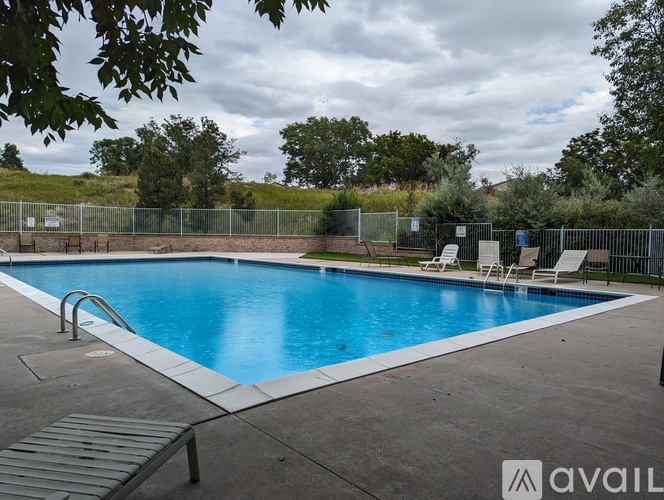 A pool surrounded by a fence and trees.