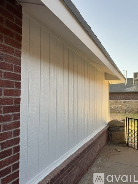 A white siding on a brick building.