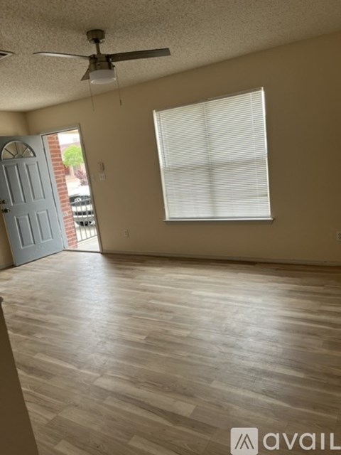 A room with a ceiling fan and a window with blinds.