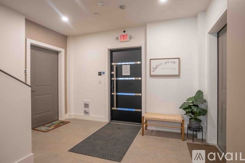 A hallway with a bench, a door, and a sign on the wall.