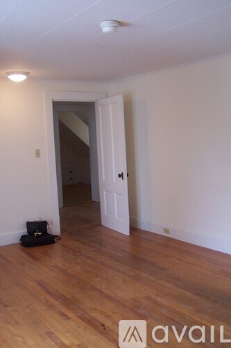 A room with a wooden floor and a white door.