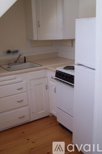 A kitchen with white appliances and cabinets.