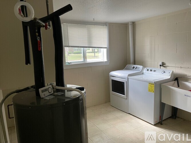 A room with a treadmill, a rowing machine, and a sink.
