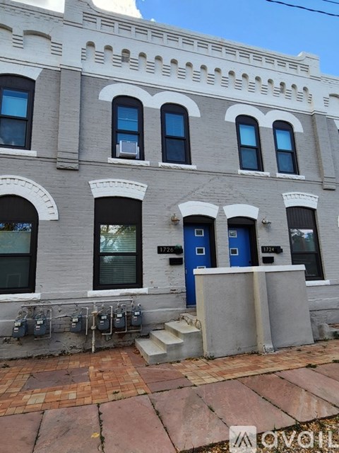 A building with a blue door and windows with white trim.