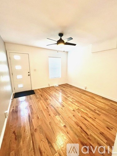 A room with wooden flooring and a ceiling fan.