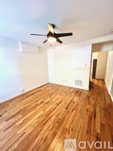 A room with wooden flooring and a ceiling fan.