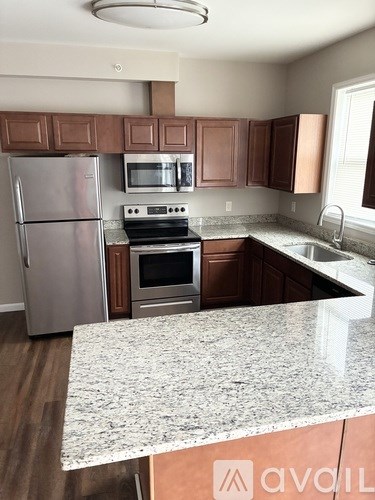 A kitchen with a granite countertop and stainless steel appliances.