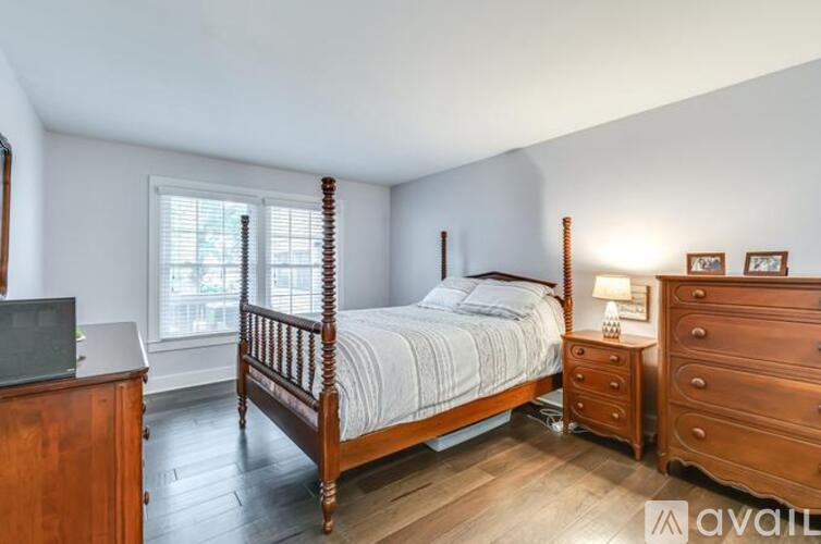 A bedroom with a bed, dresser, and nightstand.