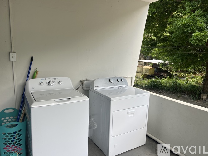 Two white front loading washing machines in a small room.