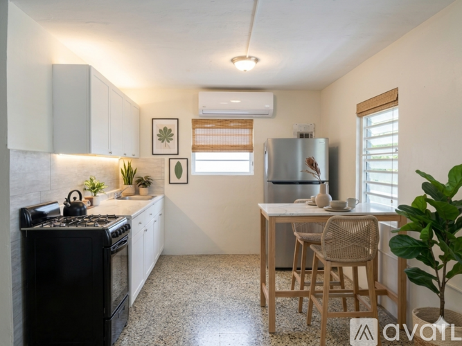 A kitchen with a black stove top oven and a white refrigerator.