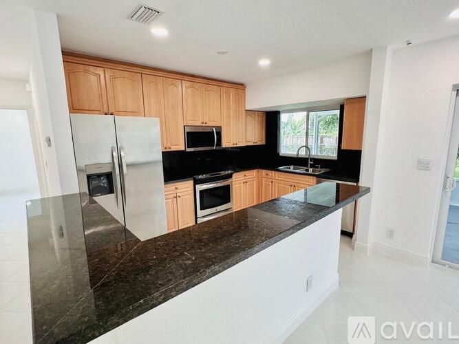 A kitchen with wooden cabinets and a black countertop.