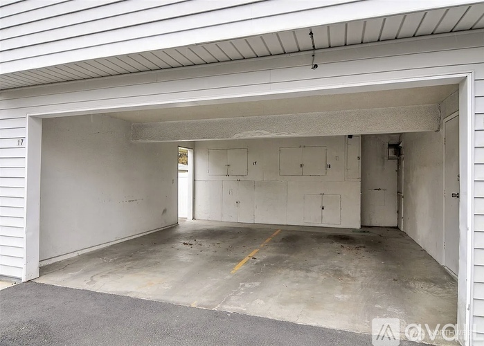 A large, empty garage with a white exterior and a concrete floor.