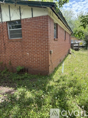 A small red brick house with a window and a door.
