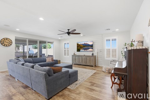A living room with a grey sofa and a wooden floor.