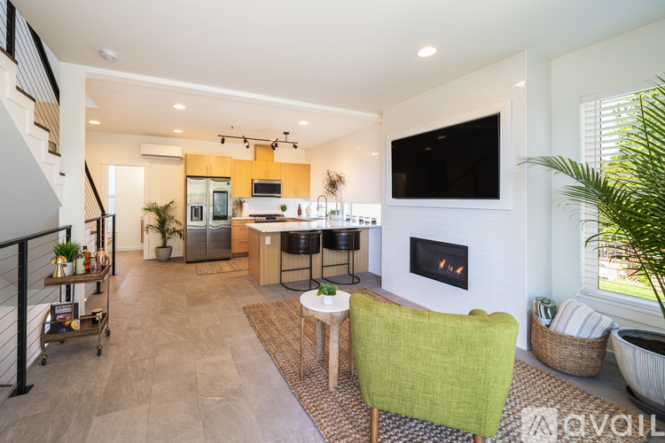 A living room with a fireplace and a green chair.
