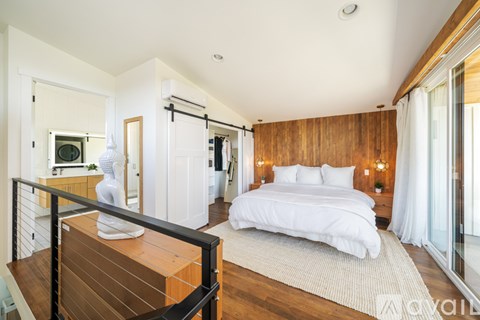 A bedroom with a large bed and a wooden headboard.