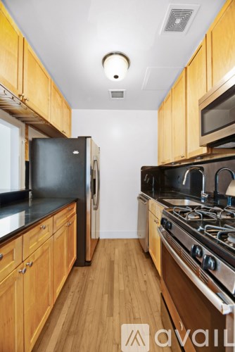 A kitchen with wooden cabinets and black appliances.