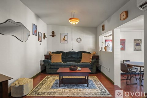 A living room with a blue sofa and a rug.