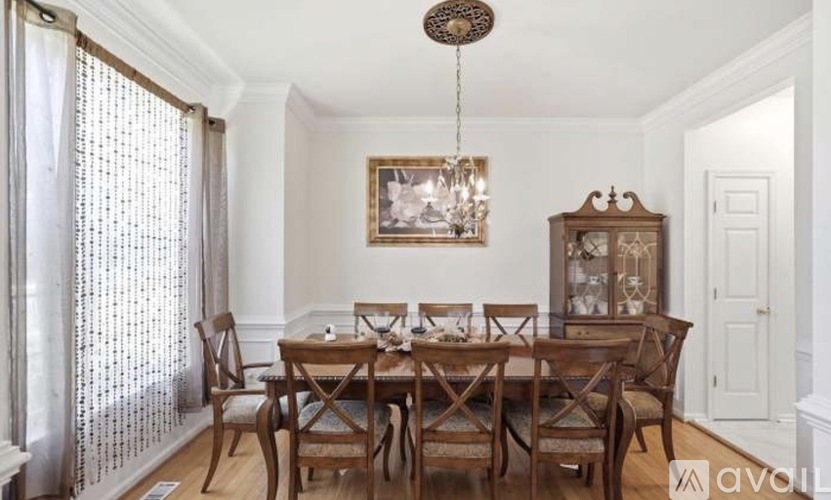 A dining room with a wooden table and chairs.