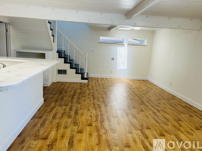 A room with wooden flooring and a staircase.