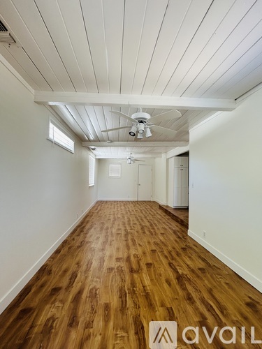 A long hallway with wooden floors and white walls.