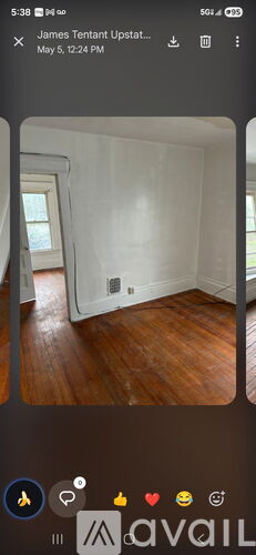 A room with wooden flooring and a white door.