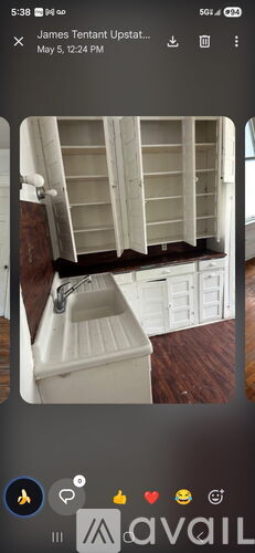 A white sink in a room with wooden flooring.