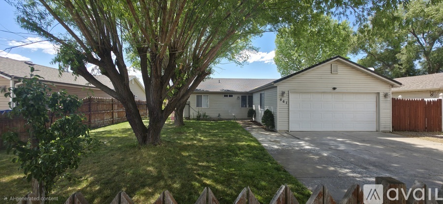 A tree in a yard with a house and garage in the background.