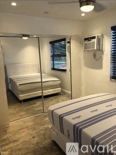 A bedroom with a bed and a mirror on the wall.