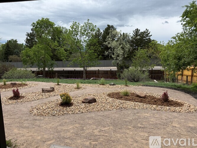 A garden with circular beds and trees in the background.