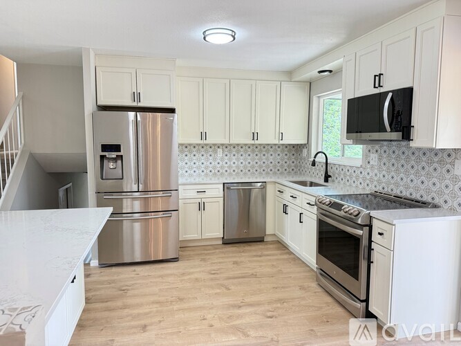 A kitchen with white cabinets and stainless steel appliances.