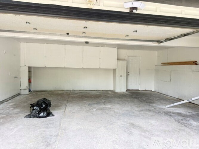 A spacious garage with a bag on the floor and a fire extinguisher on the wall.