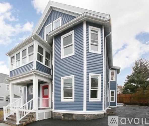 A blue house with a red door and white windows.