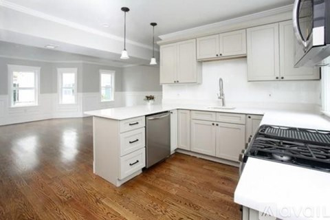 A kitchen with white cabinets and a black stove top.
